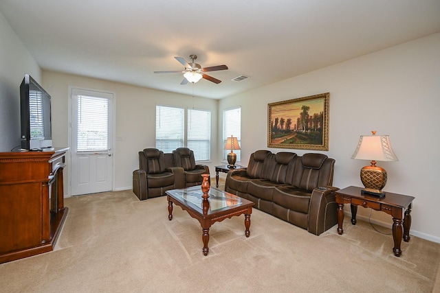 living area featuring a ceiling fan, baseboards, light colored carpet, and visible vents