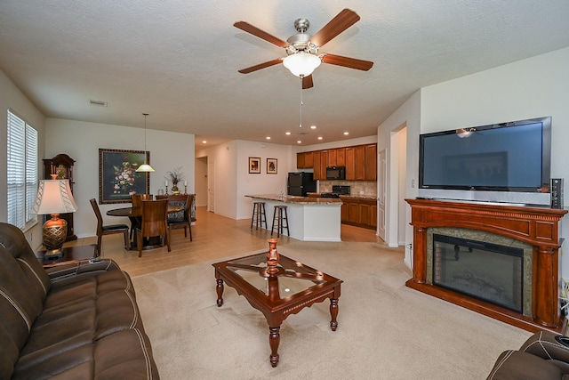living room with visible vents, light carpet, baseboards, ceiling fan, and recessed lighting