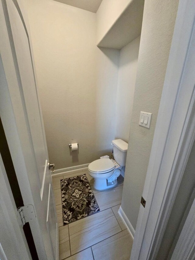 19003 Bene Vista Dr, Houston, TX 77084 - bathroom featuring toilet, baseboards, and tile patterned flooring