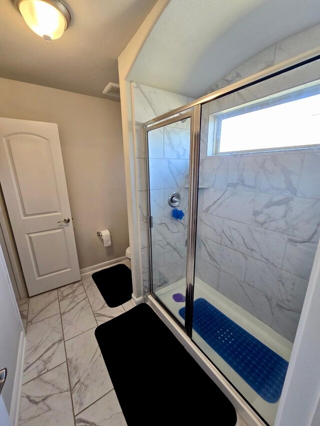 19003 Bene Vista Dr, Houston, TX 77084 - bathroom with marble look tiles, a shower stall, toilet, and baseboards