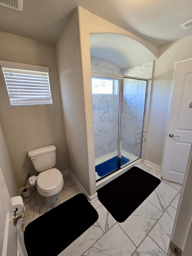 19003 Bene Vista Dr, Houston, TX 77084 - bathroom with marble look tiles, toilet, a marble finish shower, and baseboards