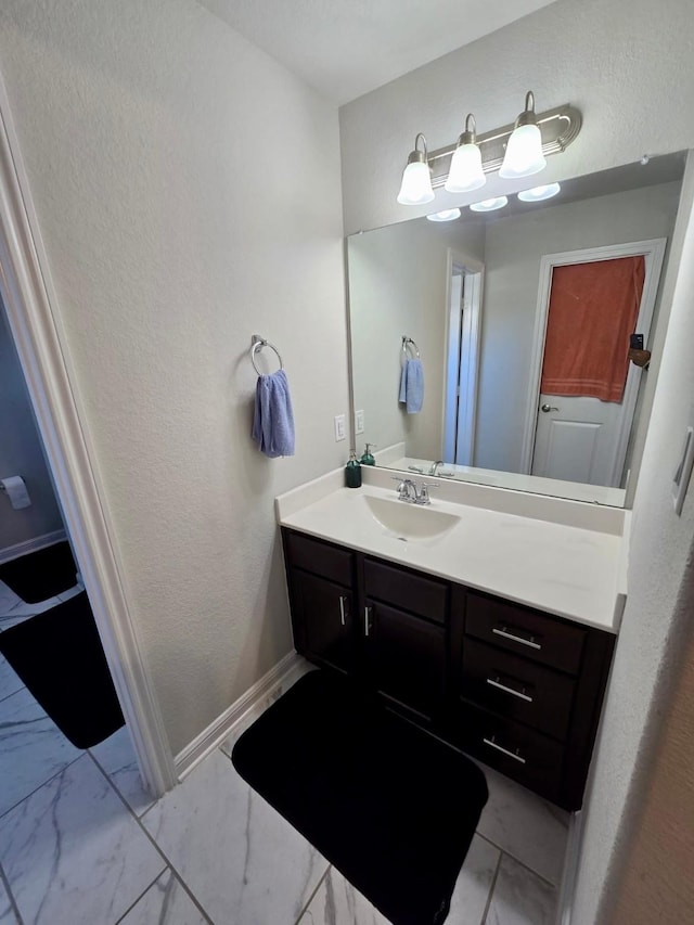 19003 Bene Vista Dr, Houston, TX 77084 - bathroom with vanity, marble finish flooring, baseboards, and a textured wall