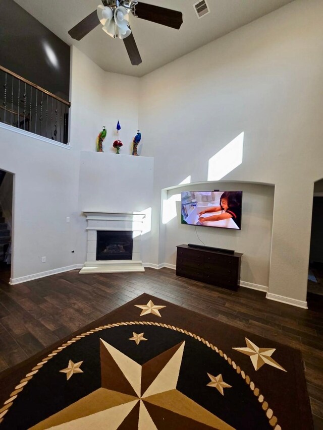 19003 Bene Vista Dr, Houston, TX 77084 - unfurnished living room with a glass covered fireplace, wood finished floors, a towering ceiling, and baseboards