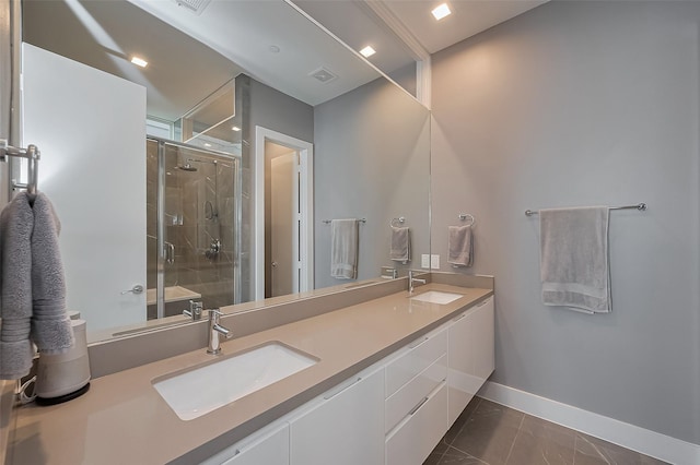 bathroom with baseboards, a stall shower, double vanity, and a sink