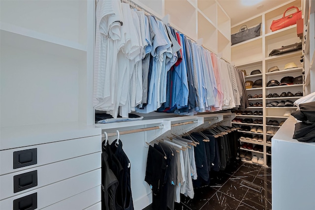 walk in closet with marble finish floor