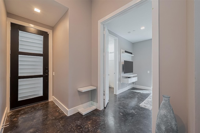 foyer with concrete floors and baseboards