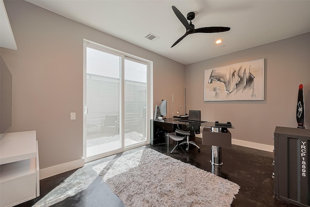 office area featuring concrete floors, visible vents, a ceiling fan, and baseboards