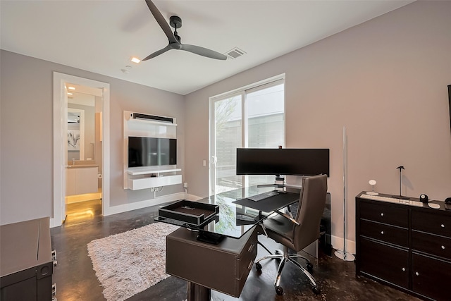office space with baseboards, visible vents, a ceiling fan, and concrete flooring