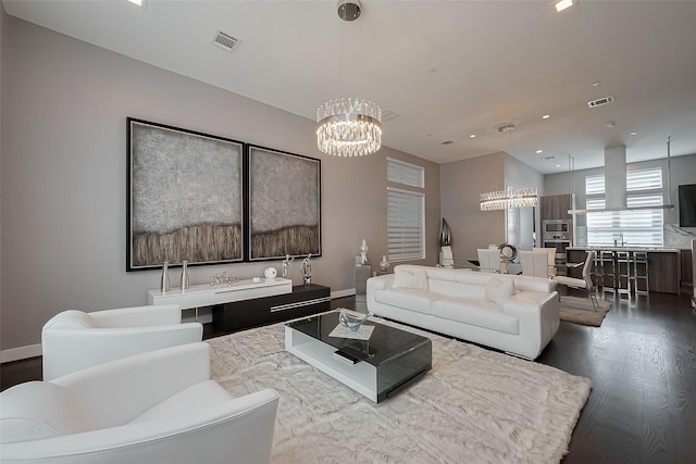 living room with recessed lighting, an inviting chandelier, visible vents, and dark wood-type flooring