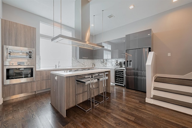 kitchen featuring dark wood-style floors, modern cabinets, stainless steel appliances, wine cooler, and island range hood