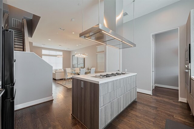 kitchen with modern cabinets, ventilation hood, dark wood-style flooring, and visible vents