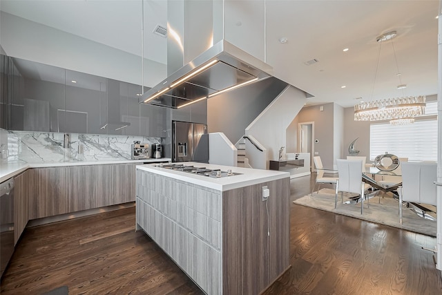 kitchen with dark wood-style floors, modern cabinets, stainless steel appliances, decorative backsplash, and a center island