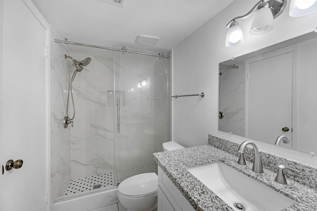 full bathroom with toilet, vanity, and a marble finish shower