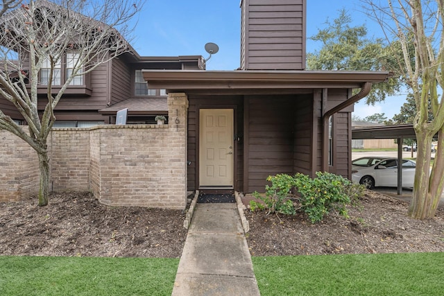 entrance to property with brick siding and a chimney