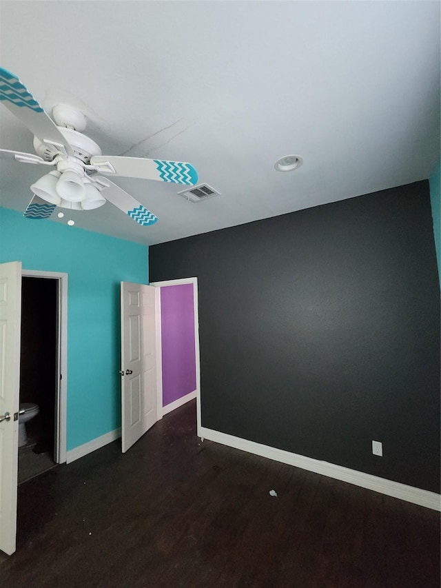 unfurnished bedroom with wood finished floors, visible vents, baseboards, and ceiling fan