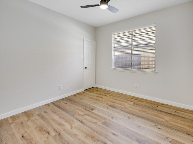 spare room featuring light wood-type flooring, ceiling fan, and baseboards