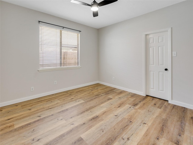 empty room featuring baseboards, a ceiling fan, and light wood finished floors