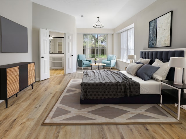 bedroom with visible vents, baseboards, ensuite bathroom, a chandelier, and wood finished floors