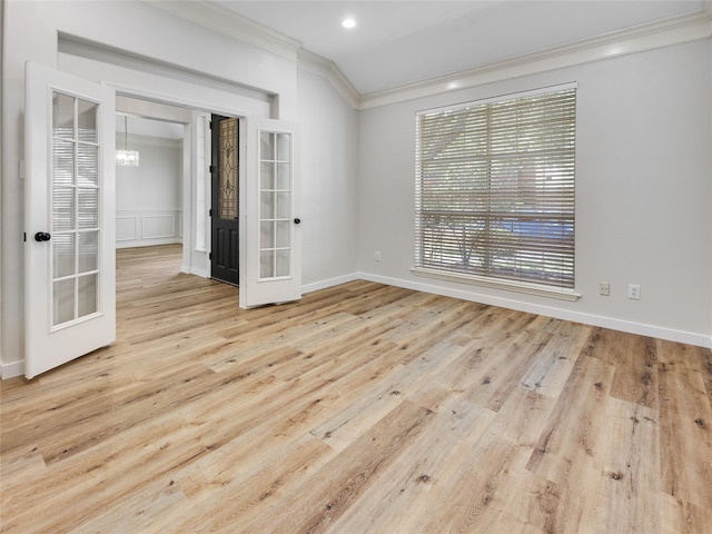 empty room featuring french doors, baseboards, ornamental molding, and wood finished floors