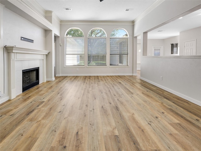 unfurnished living room featuring wood finished floors, baseboards, and visible vents