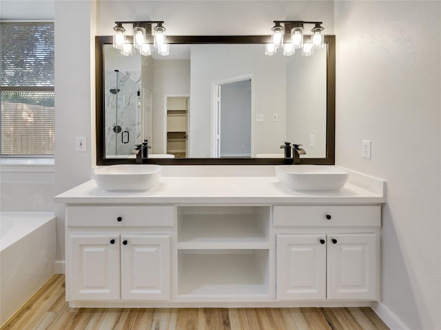 bathroom with a shower stall, a sink, and wood finished floors