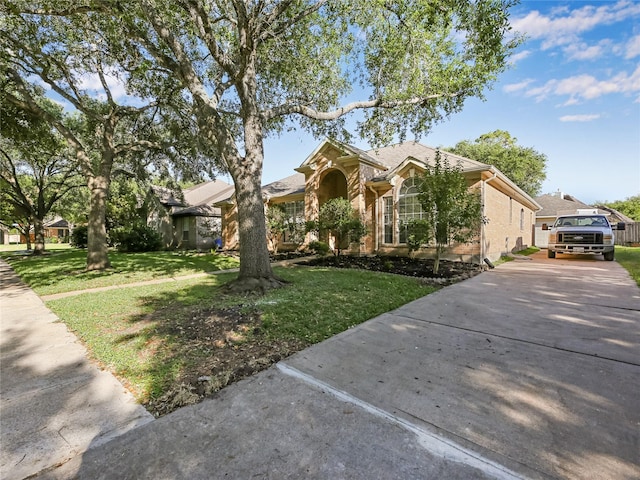 view of front facade with concrete driveway and a front yard