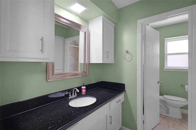 bathroom featuring tile patterned floors, vanity, and toilet