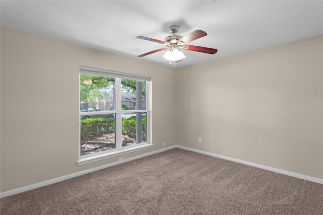 empty room with carpet flooring, ceiling fan, and baseboards
