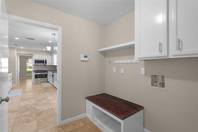 clothes washing area with cabinet space, visible vents, baseboards, and hookup for a washing machine