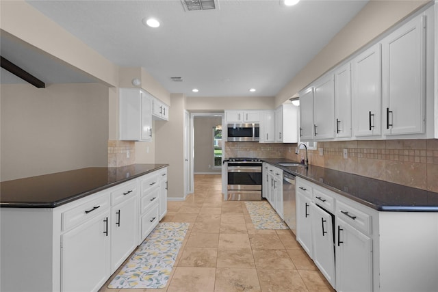 kitchen featuring dark countertops, a sink, and appliances with stainless steel finishes