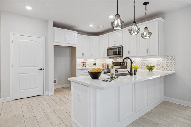 6804 Westview Dr Unit 1407, Houston, TX 77055 - kitchen with a peninsula, stainless steel appliances, white cabinetry, light countertops, and tasteful backsplash