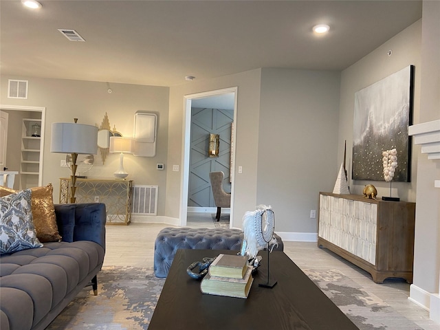 living area with recessed lighting, visible vents, baseboards, and wood finished floors