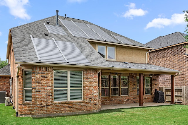 back of property with roof with shingles, fence, ceiling fan, a patio, and a yard