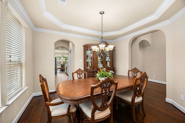 dining room with visible vents, crown molding, arched walkways, an inviting chandelier, and a tray ceiling