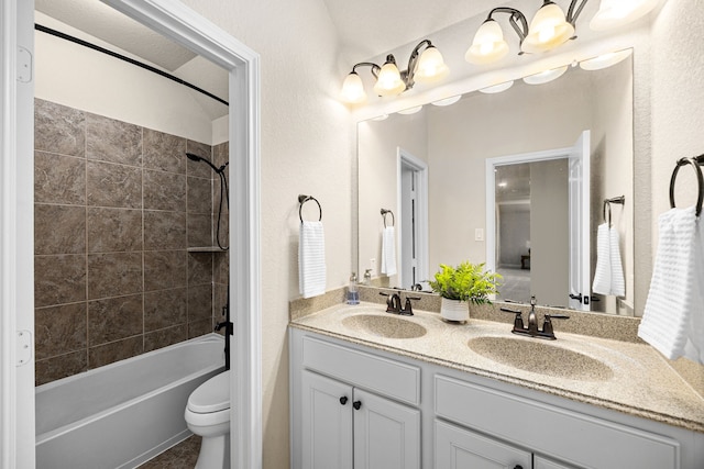 bathroom with double vanity, toilet, a sink, and shower / bathing tub combination
