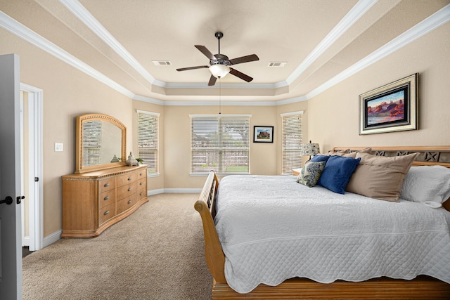 bedroom with crown molding, visible vents, light colored carpet, and a raised ceiling