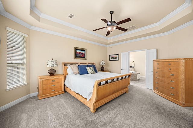 bedroom with baseboards, ornamental molding, a tray ceiling, and light carpet