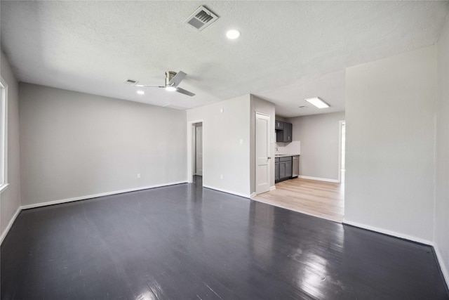 5206 Willow Glen Dr, Houston, TX 77033 - unfurnished living room featuring light wood-style floors, ceiling fan, a textured ceiling, visible vents, and baseboards