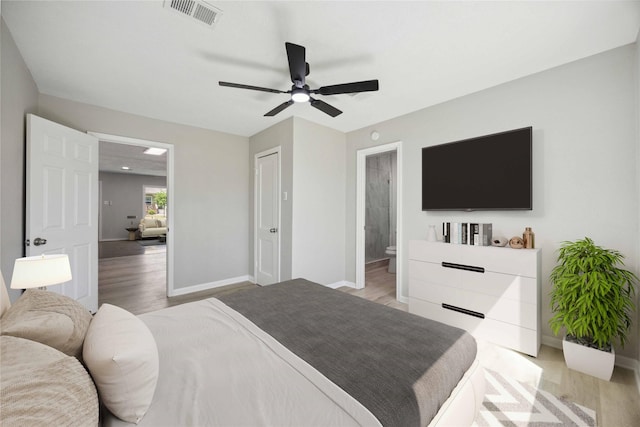 5206 Willow Glen Dr, Houston, TX 77033 - bedroom featuring baseboards, ensuite bath, a ceiling fan, visible vents, and light wood finished floors