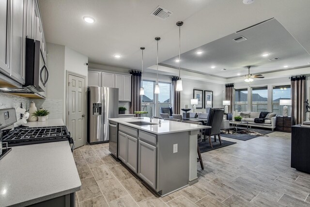 26719 Grandiflora Dr, Magnolia, TX 77355 - kitchen with appliances with stainless steel finishes, a sink, a ceiling fan, backsplash, and open floor plan