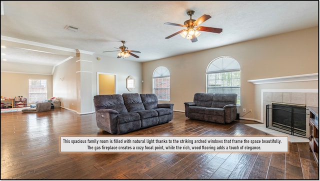 living area featuring wood-type flooring, ceiling fan, visible vents, and a fireplace