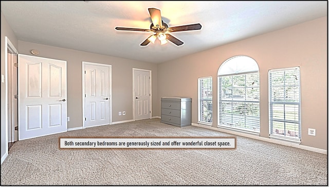 unfurnished bedroom featuring two closets, ceiling fan, baseboards, and carpet floors