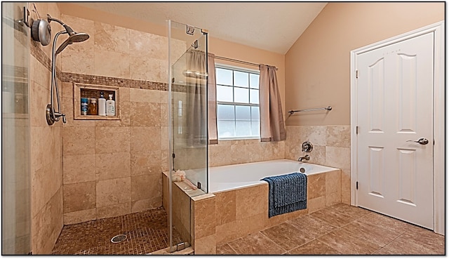 bathroom with vaulted ceiling, a garden tub, and a stall shower