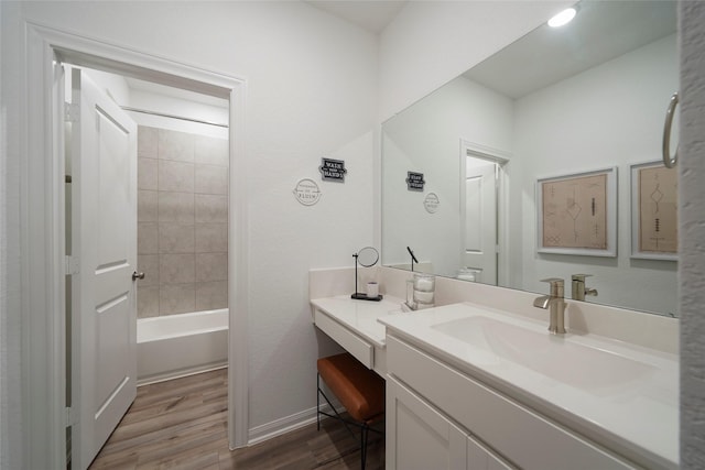 bathroom featuring bathing tub / shower combination, baseboards, vanity, and wood finished floors