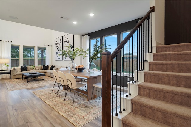 dining space featuring stairway, visible vents, light wood-type flooring, and a healthy amount of sunlight