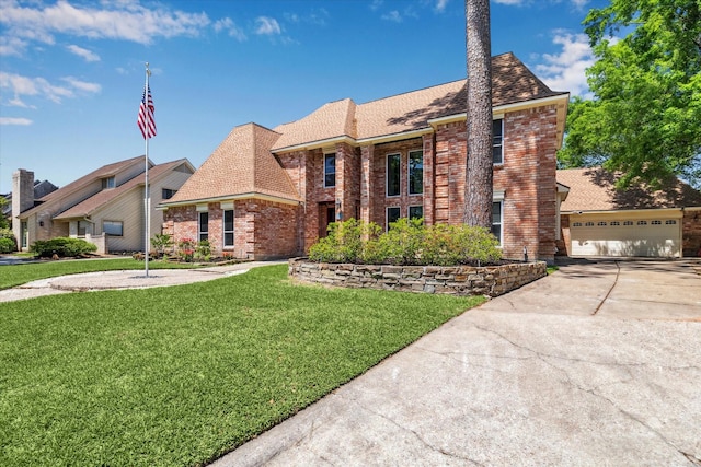 tudor house featuring concrete driveway, a front yard, and brick siding