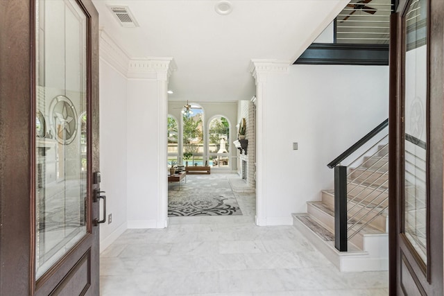 foyer with visible vents, baseboards, a ceiling fan, ornate columns, and stairs