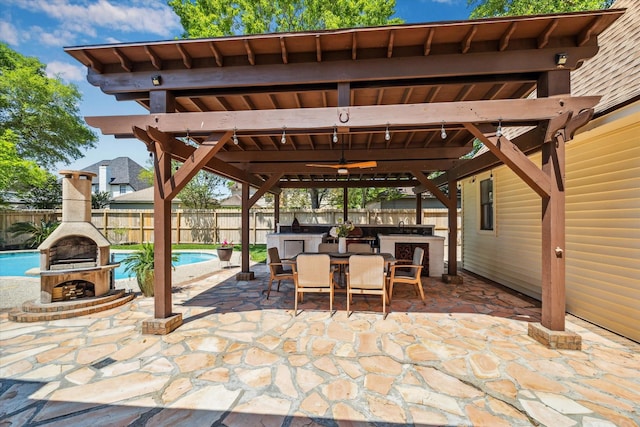 view of patio with an outdoor fireplace, a fenced backyard, exterior kitchen, outdoor dining space, and a fenced in pool
