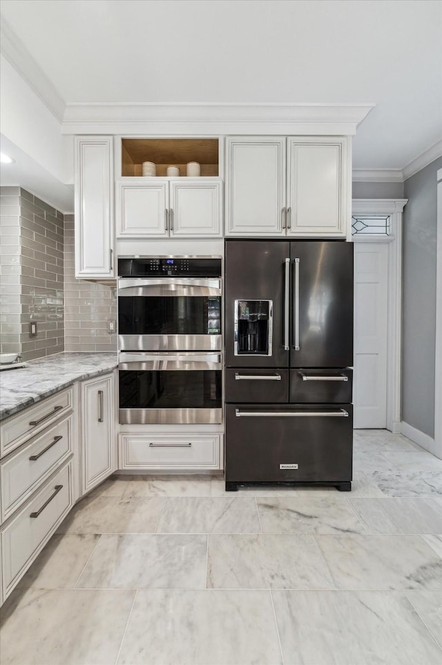 kitchen featuring ornamental molding, stainless steel double oven, light stone countertops, decorative backsplash, and high end refrigerator