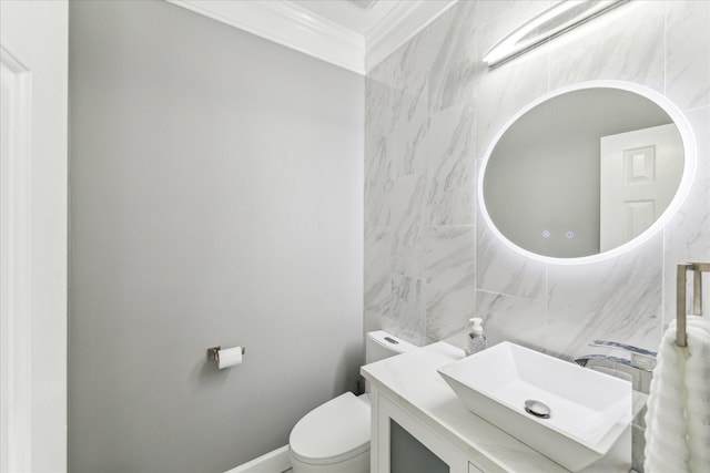 half bath featuring vanity, tile walls, crown molding, and toilet